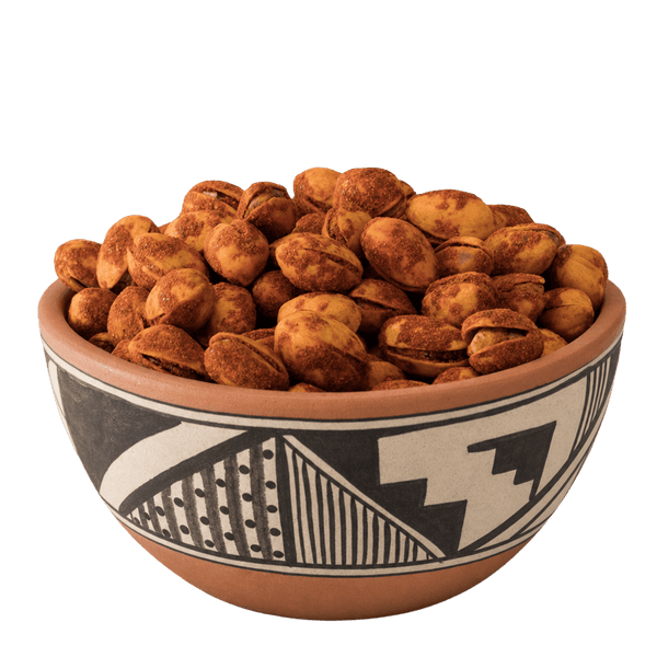 Red chile-dusted pistachios in shell in a Pueblo-patterned terracotta bowl