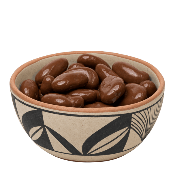 Chocolate covered pecans in a black-and-tan Pueblo pottery bowl