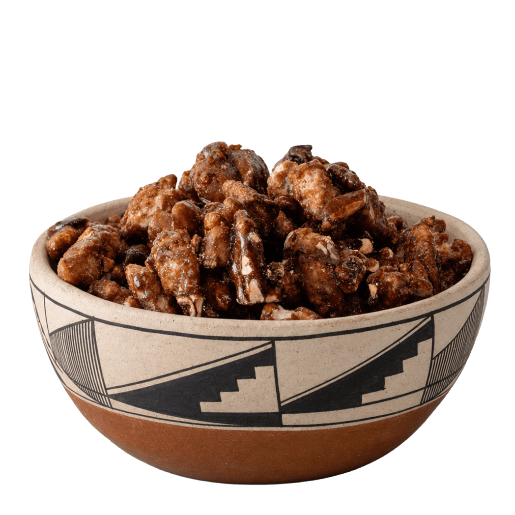 Glazed candied pecans in a Southwestern black-and-cream patterned ceramic bowl
