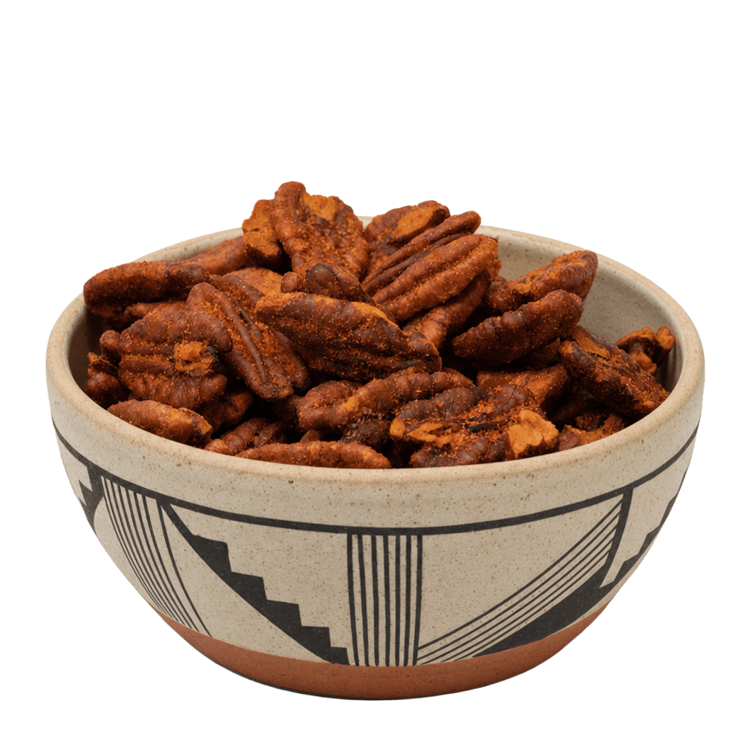 Red chile pecans in a Southwestern black-and-tan patterned ceramic bowl