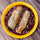 Two Hatch chile rellenos over red chile sauce with crumbled cotija