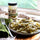 Jar of roasted Hatch green chile, medium, beside a plate of green chile pasta