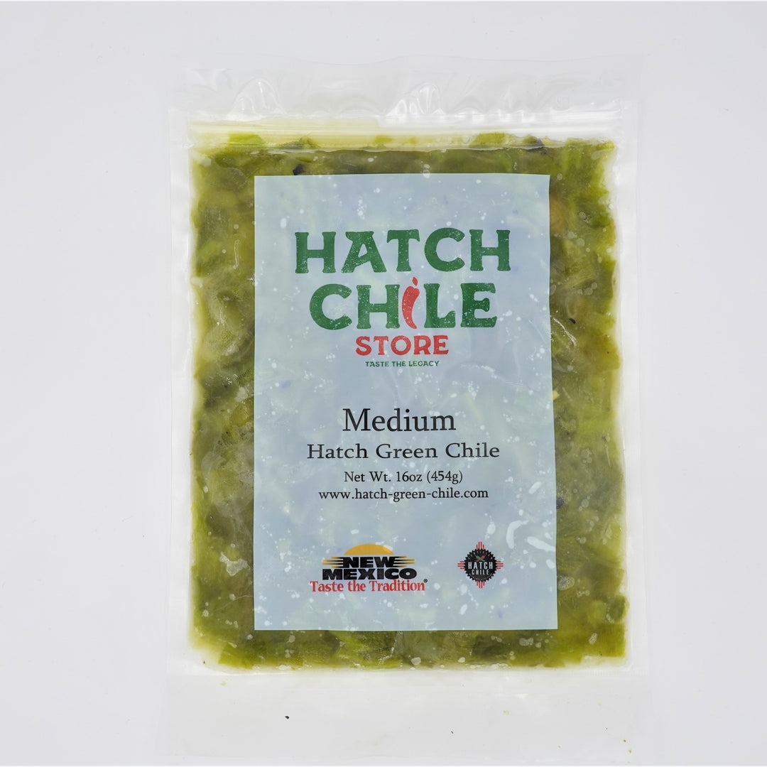 A sealed plastic bag of Roasted Hatch Green Chile sauce, medium heat, weighing 16 ounces, against a white background. The packaging features branding and product details.