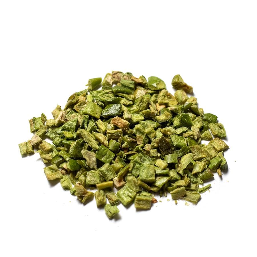 A pile of Freeze Dried Chopped Hatch Green Chile, prominently displayed against a bright white background. The chiles appear vibrant and are irregularly shaped, suggesting they are natural and roughly cut.