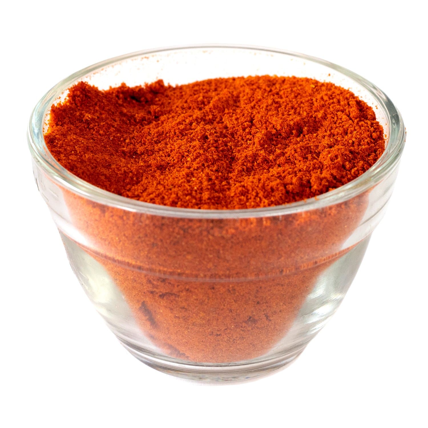 A glass bowl filled with Red Chile Powder, isolated on a white background.