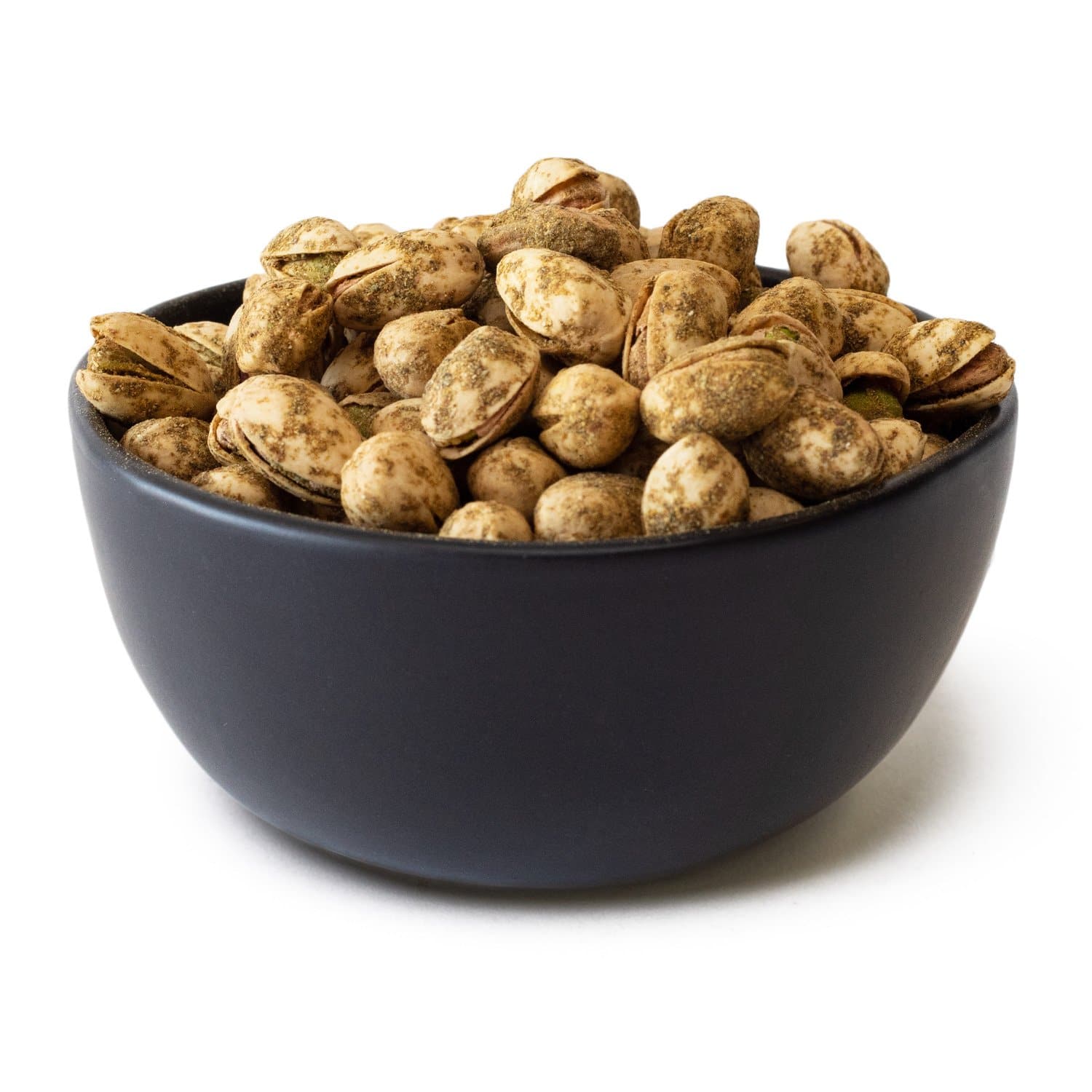A bowl filled with Green Chile Pistachios on a white background. The bowl is dark blue and contrasts with the light green, textured surface of the pistachios.