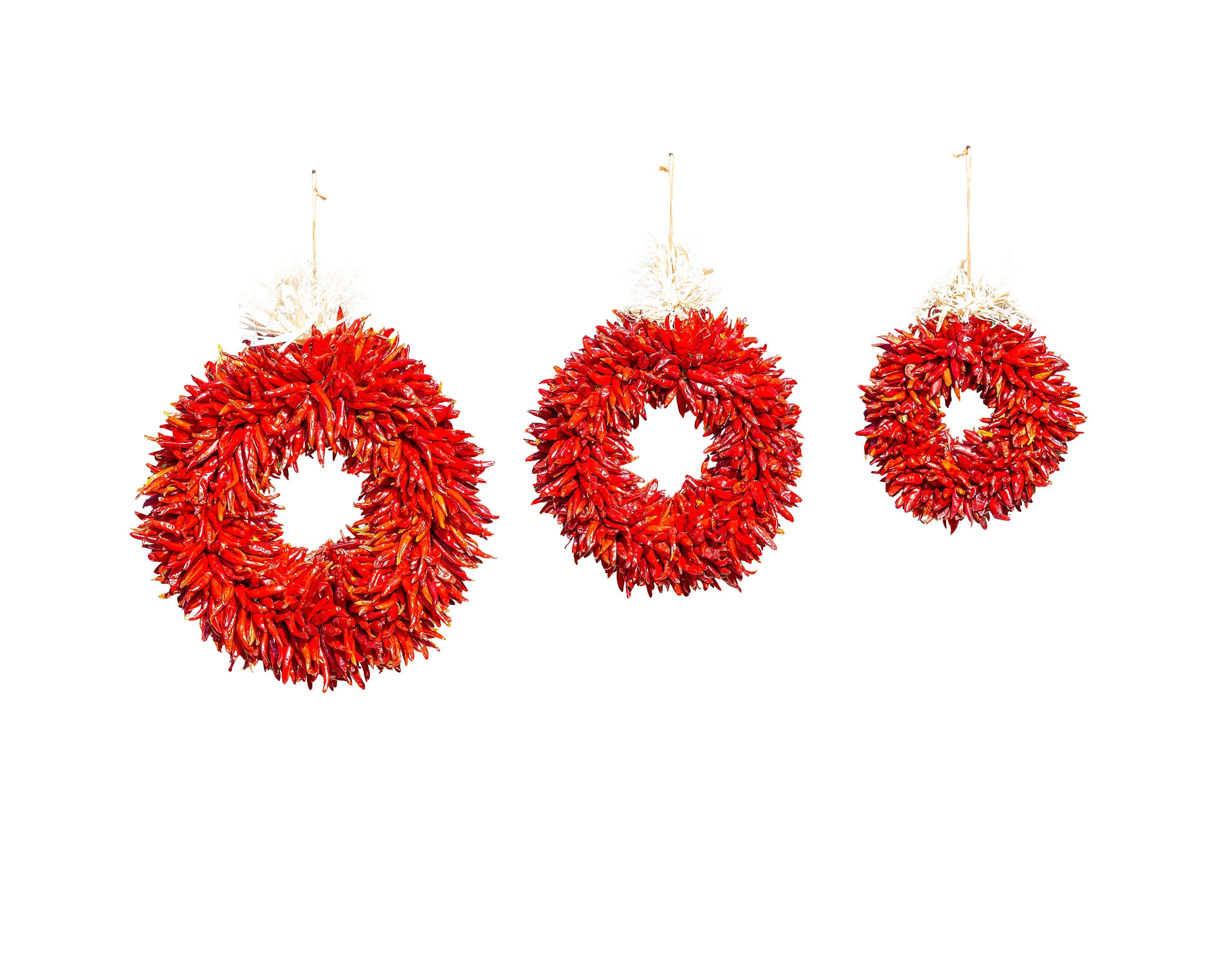 Three hand-made Chile Pequin Wreaths hanging against a white background, varying in size from large to small, arranged in a horizontal line.