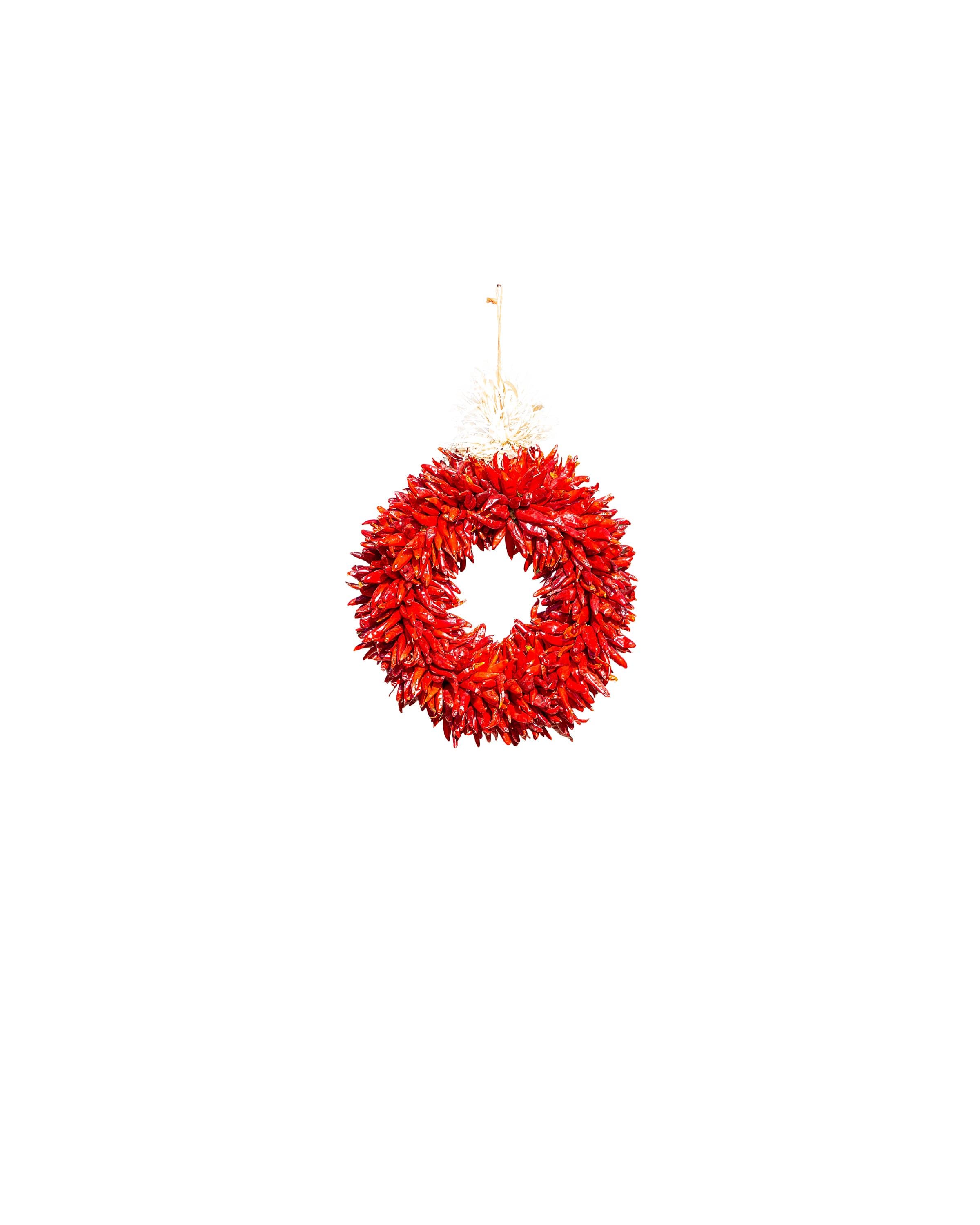 A vibrant red Chile Pequin Wreaths hanging against a plain white background.