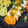 Chicken chimichangas topped with white sauce, green chile salsa and cilantro, with guacamole and lime