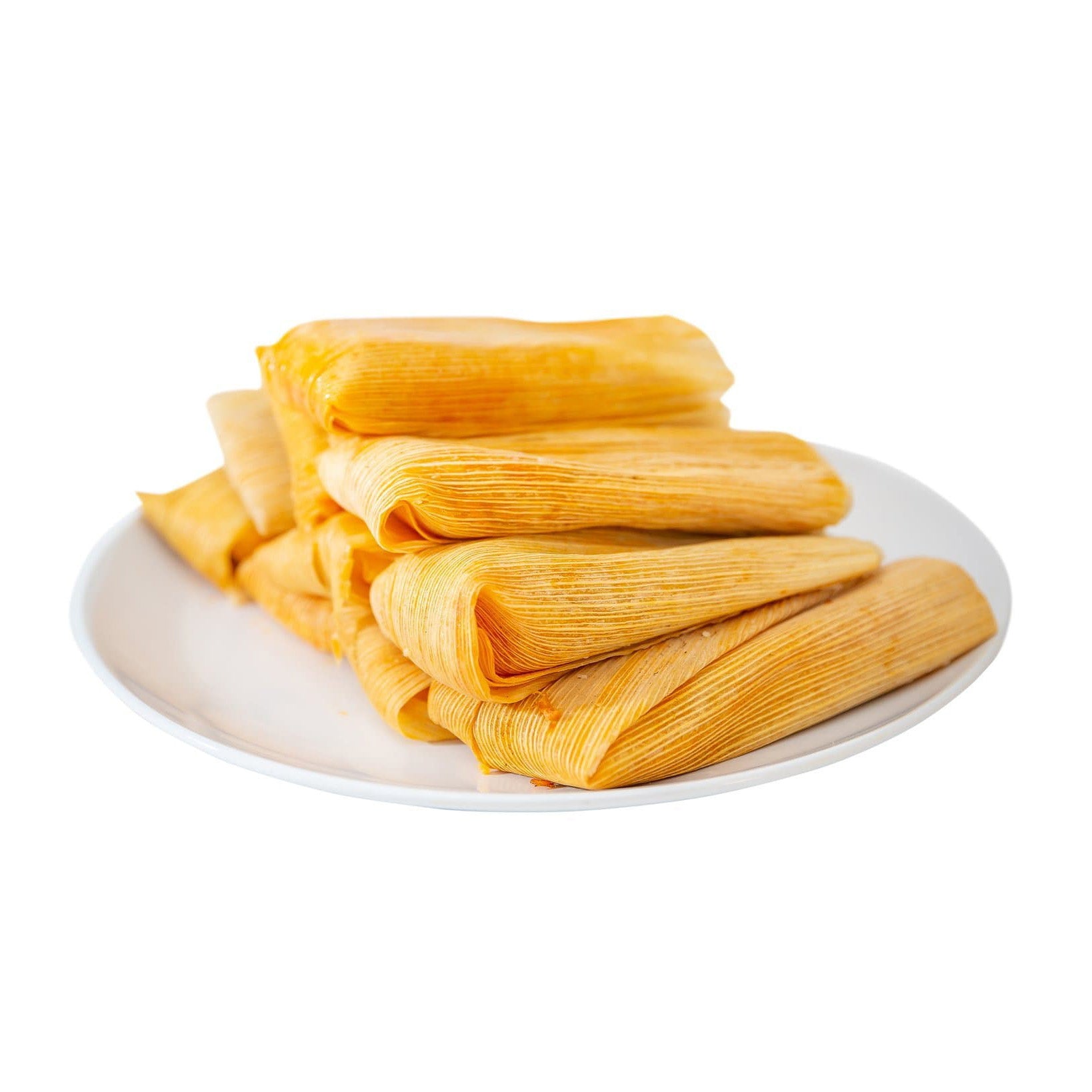 A stack of freshly made Pork Carnitas Tamales wrapped in corn husks, arranged neatly on a white plate, with a clean white background.