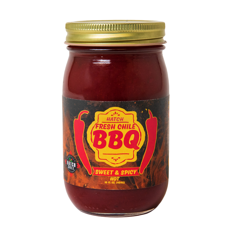 A jar of Sweet & Spicy Hatch Red Chile BBQ sauce labeled "sweet & spicy" and "hot," with red and orange fiery design elements around the text, set against a transparent background.