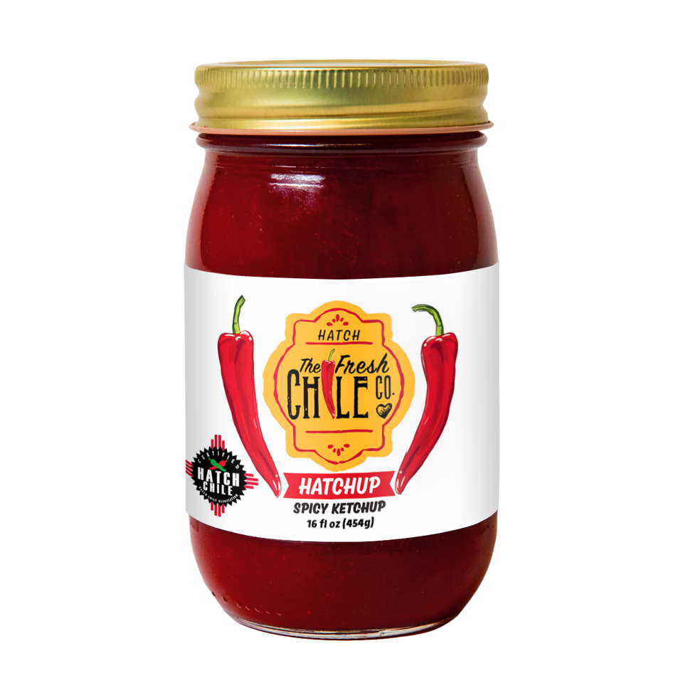 A glass jar of Hatchup - Spicy Hatch Red Chile Ketchup from the Fresh Chile Co. The label features a vibrant graphic of two red chili peppers, the company logo, and the product name.