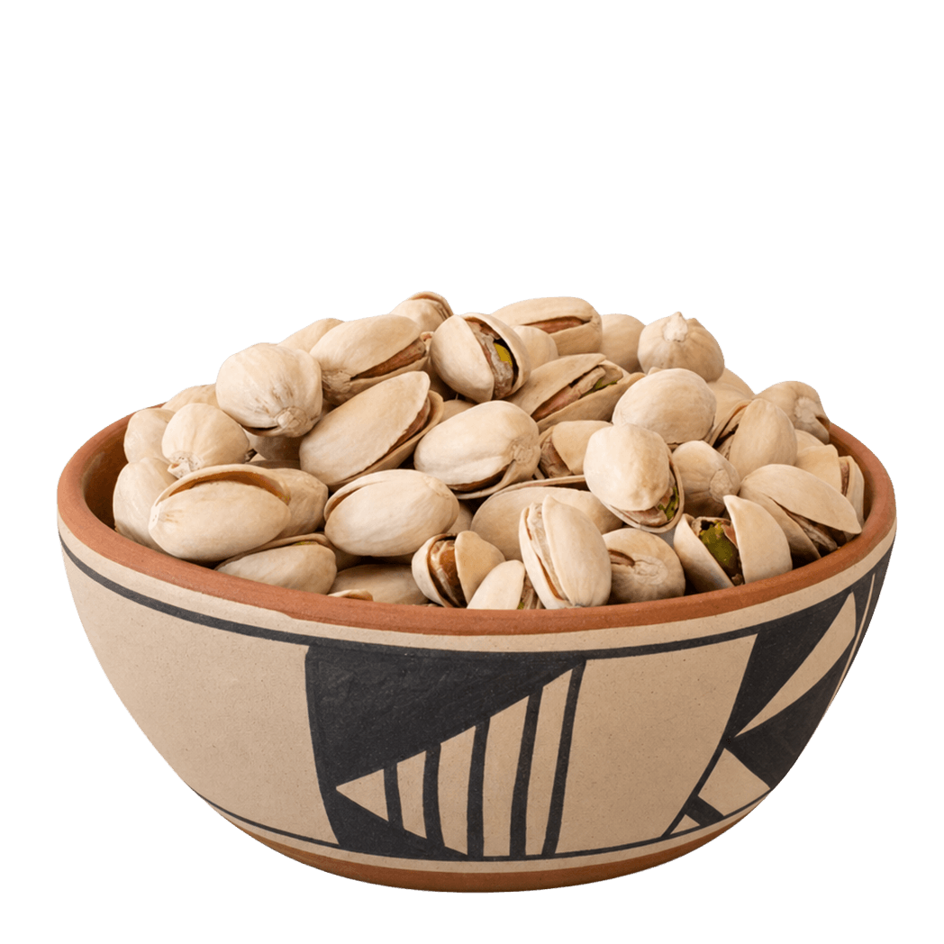 Roasted salted pistachios in shells in a Pueblo-patterned ceramic bowl