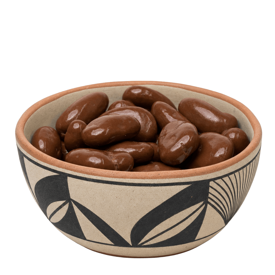 Chocolate amaretto covered pecans in a black-and-cream Southwestern pottery bowl