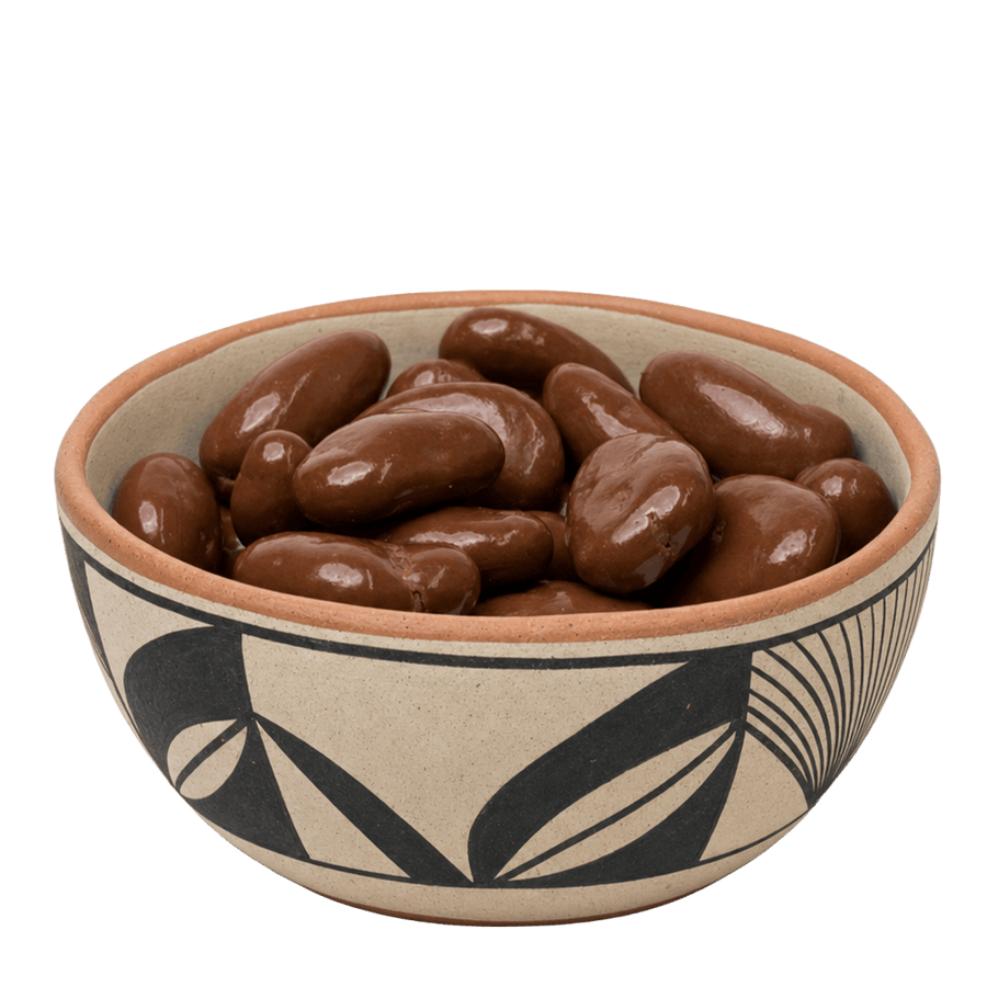 Chocolate amaretto covered pecans in a black-and-cream Southwestern pottery bowl