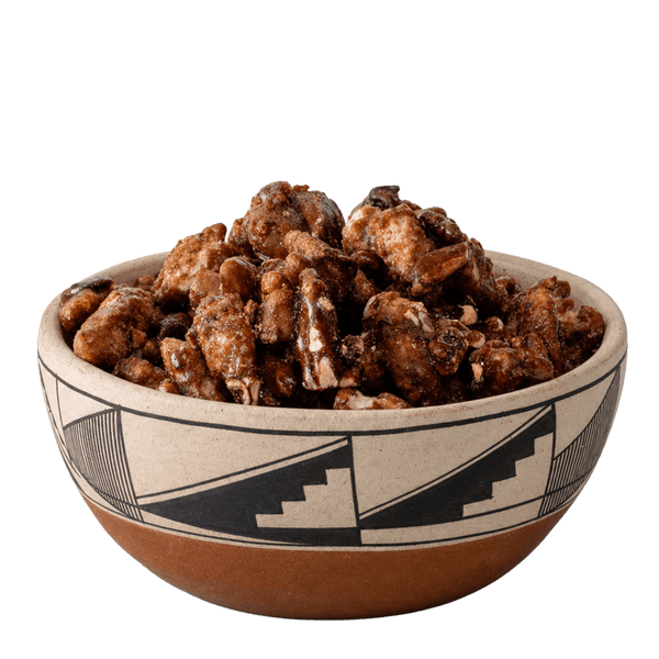Glazed candied pecans in a Southwestern black-and-cream patterned ceramic bowl