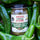 Jar of roasted Hatch green chile, hot, on a bed of fresh green chile pods