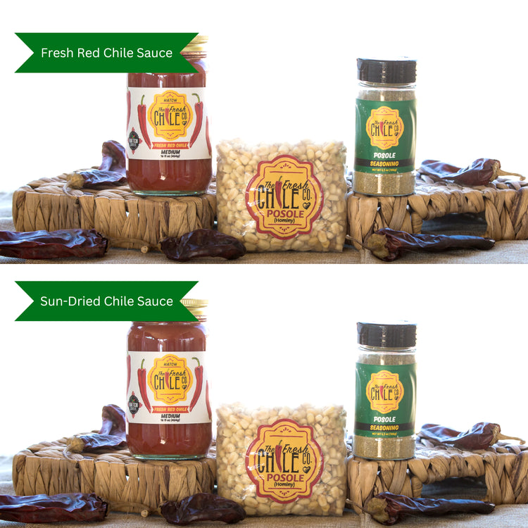 Two Posole Pack displays, each with a jar of sauce, a seasoning shaker, dried chilies, and labeled packets of white hominy, placed on a wicker mat.