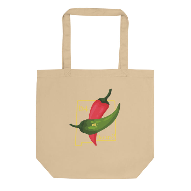 A beige NM State Question Tote Bag featuring a graphic of two colorful chili peppers, one red and one green, with the phrase "best oil ever!" in a stylized yellow box.