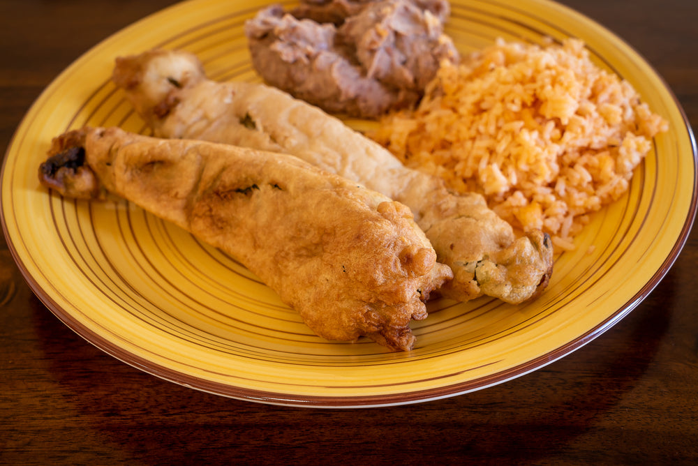 hatch chile rellenos fried to a crispy brown along with sides of refried beans and spanish rice