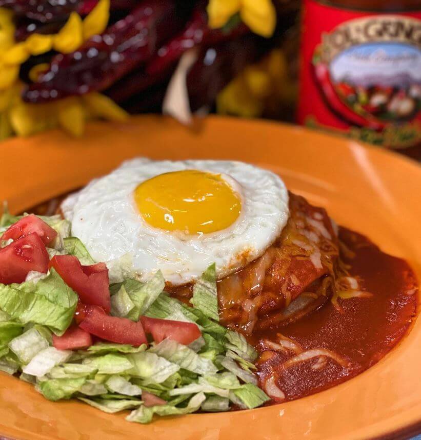 Red chile enchiladas topped with a fried egg, made with Ol' Gringo Red Chile Sauce