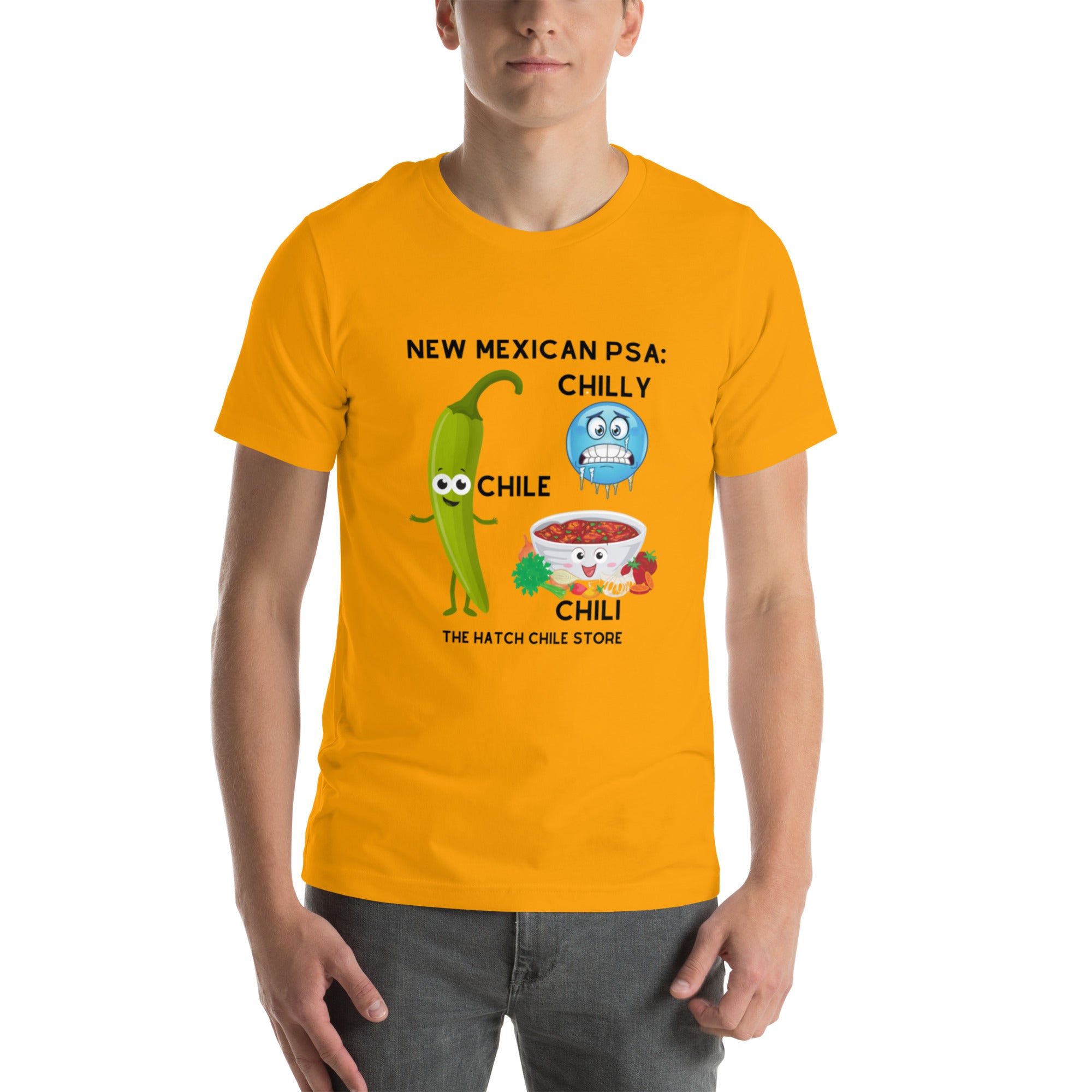 A young man wearing a bright yellow, lightweight PSA Shirt featuring a humorous design with cartoon chili peppers and the text "new mexican psa: chilly, chile, chili - the hatch chile