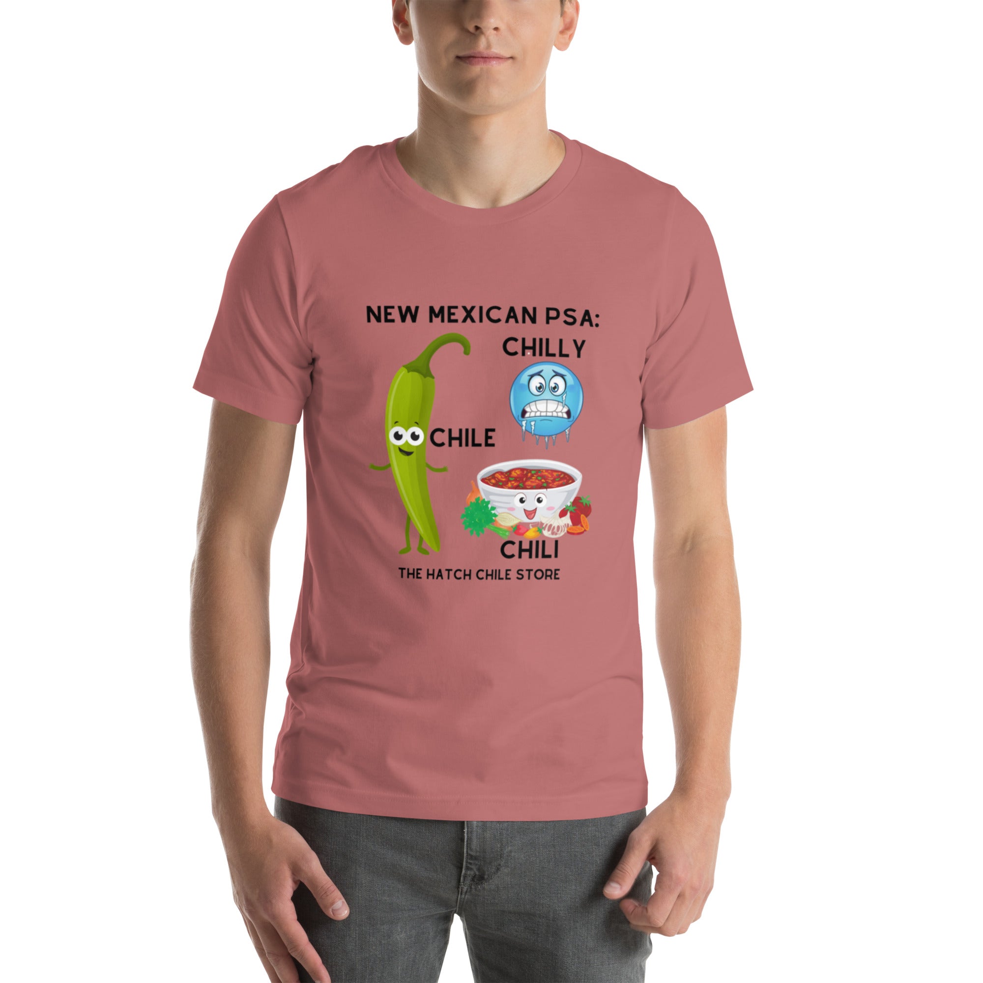 A young man wearing a pink, lightweight PSA Shirt with a cartoon design featuring a green chili, a blue chilly character, and a red chili bowl.