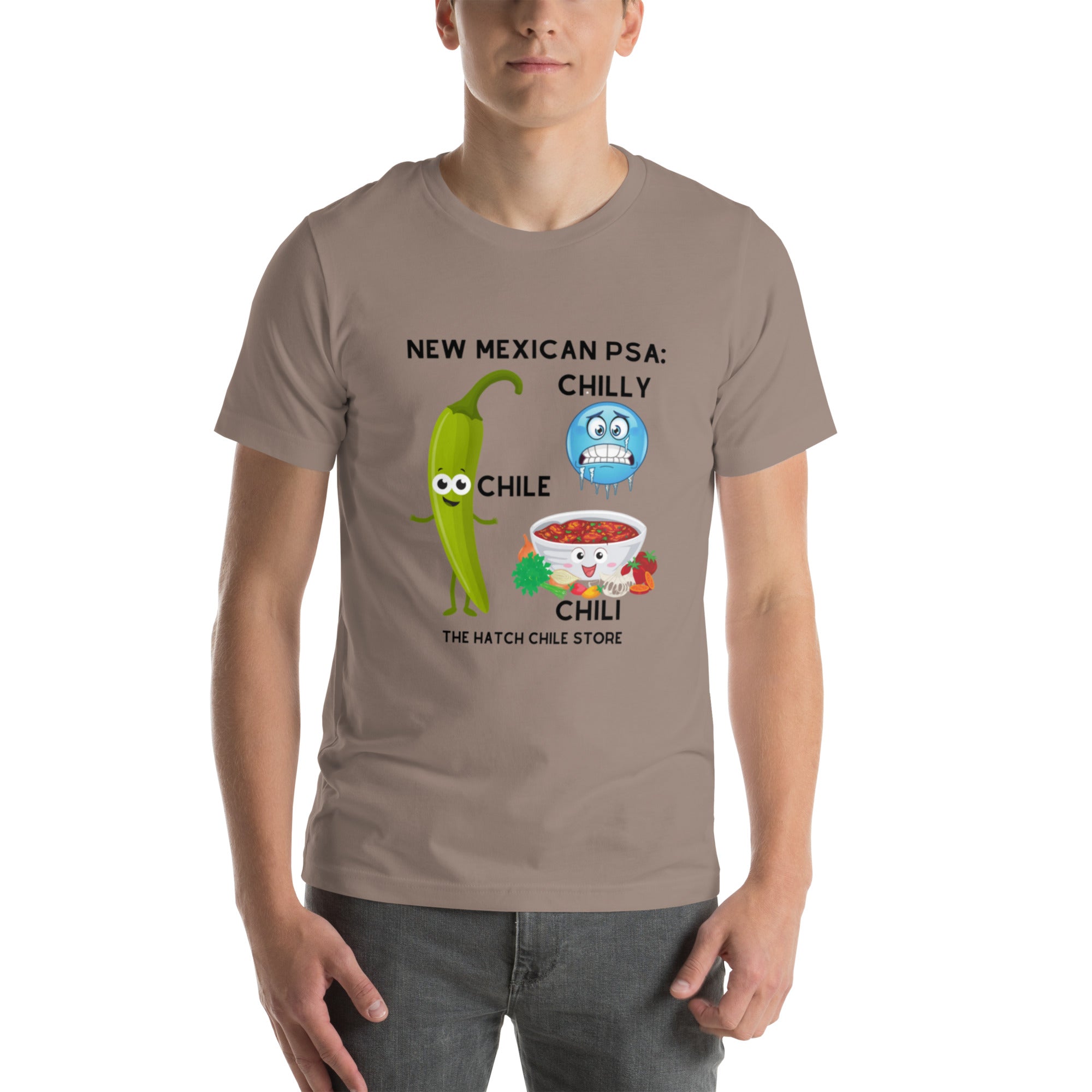 A man is wearing a lightweight taupe PSA Shirt with a cartoon graphic featuring a green chili and a bowl of chili con carne. The text reads "New Mexican PSA: Chilly Chili - The Hatch".