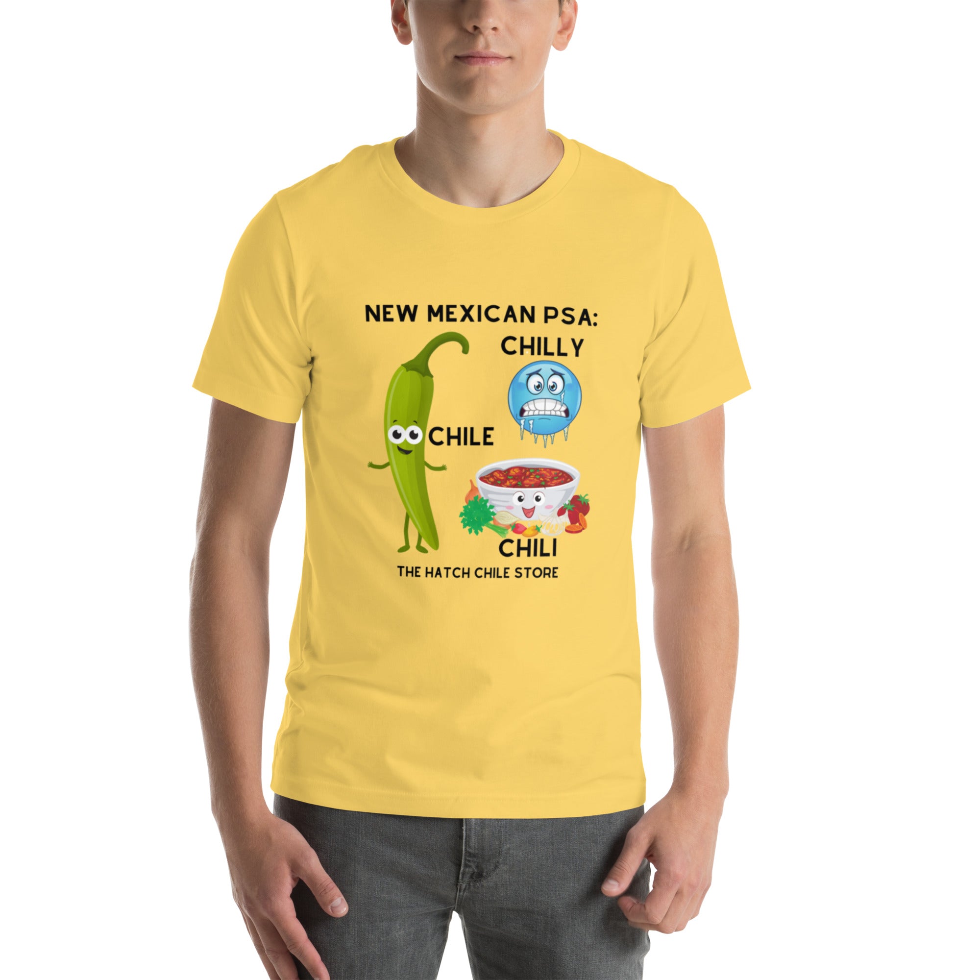 Young man wearing a PSA Shirt made of combed cotton, featuring a humorous design with cartoon illustrations of a green chili pepper, a bowl of chili, and text that says "New Mexican PSA.