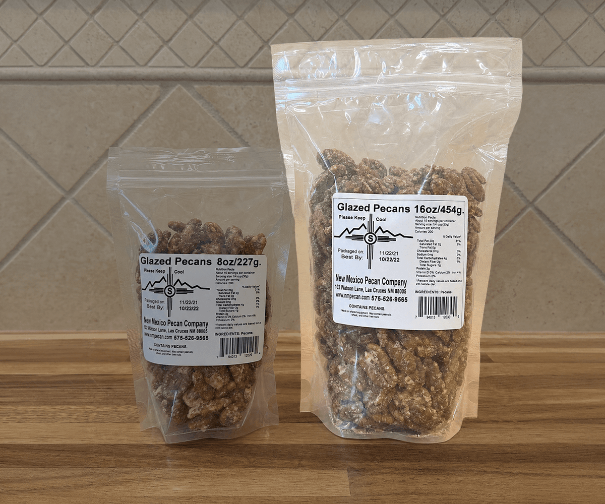 Glazed pecans in 8 oz and 16 oz clear resealable bags on a wooden counter
