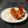 Ladling Red Chile sauce over eggs, bacon and potatoes