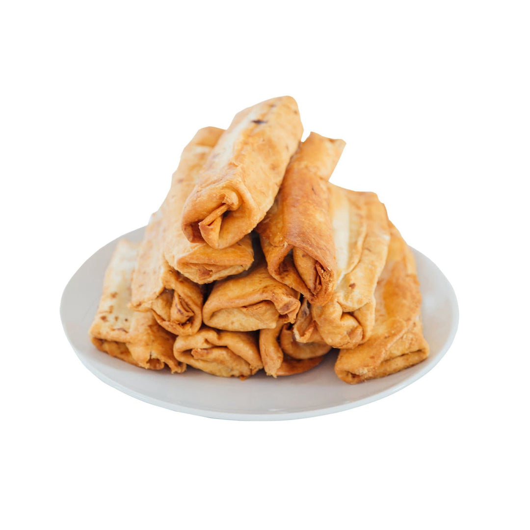 A plate of crispy, golden-brown Hatch Green Chile Beef & Cheese Chimichangas, served on a round white plate, isolated on a white background.