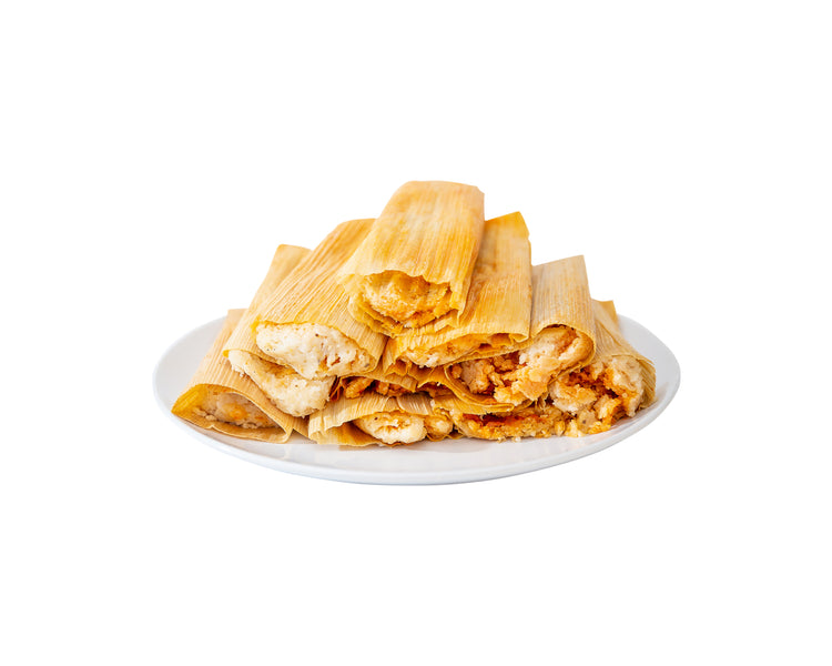 A plate of Meat Lover Sampler chicken tamales wrapped in yellow corn husks, isolated on a white background.