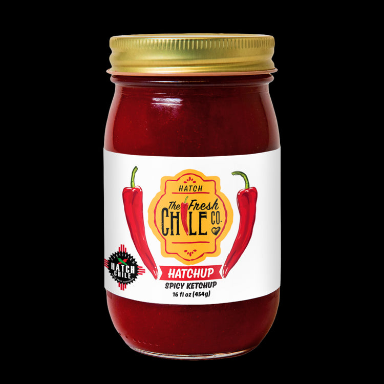 A glass jar of Hatchup - Spicy Hatch Red Chile Ketchup from the Fresh Chile Co. The label features a vibrant graphic of two red chili peppers, the company logo, and the product name.