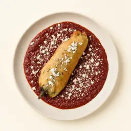 Hatch chile relleno over red chile sauce with cotija cheese